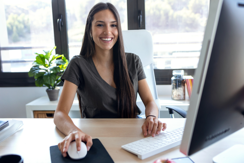 smiling woman working on computer in office